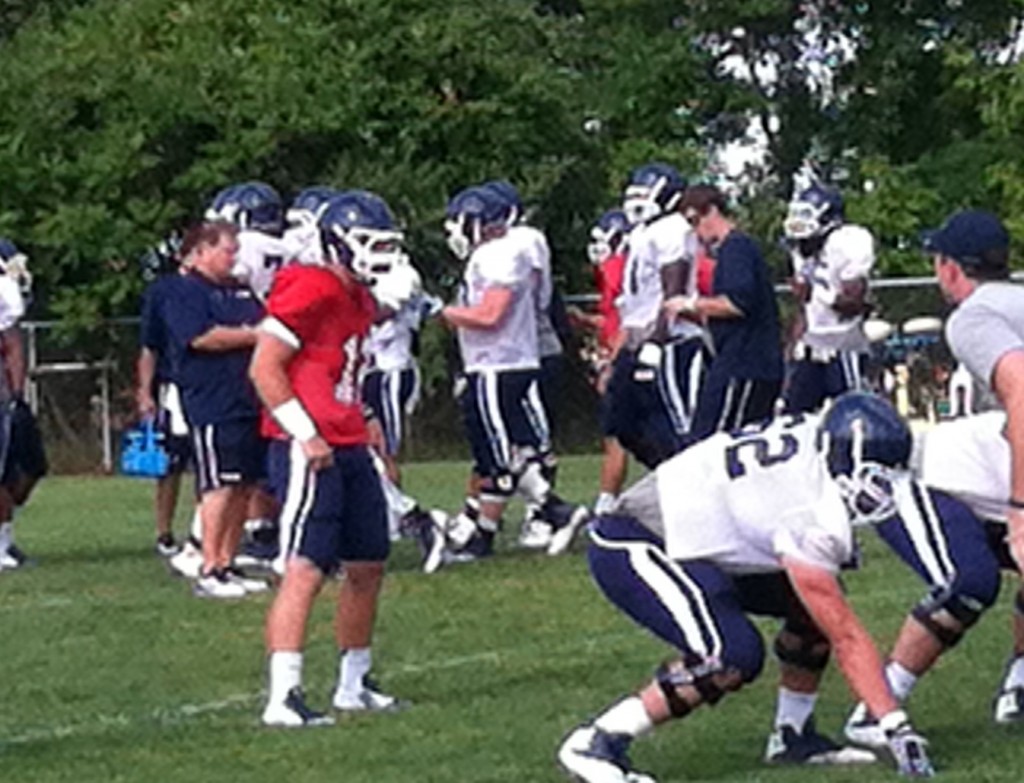 Casey Cochran, in red jersey at practice Monday, is UConn's starting QB.